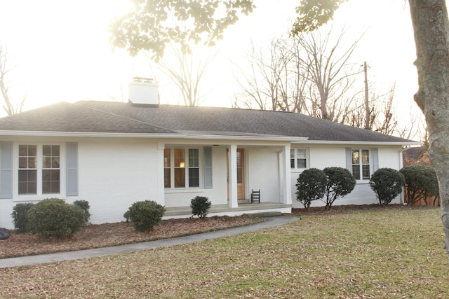 single story home featuring covered porch and a front lawn