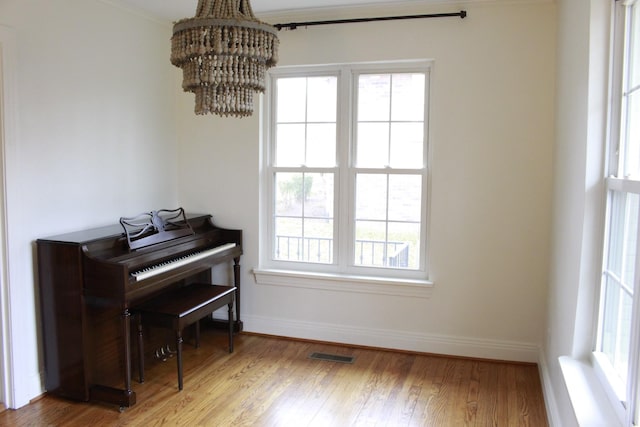 misc room featuring wood-type flooring and a chandelier