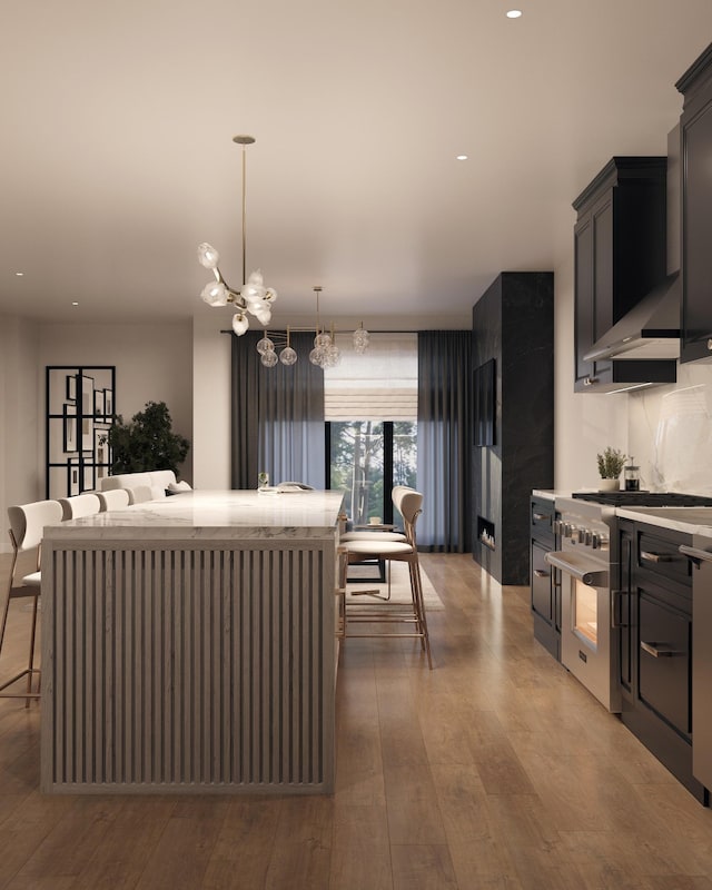 kitchen with pendant lighting, light hardwood / wood-style flooring, backsplash, a kitchen island, and a kitchen bar