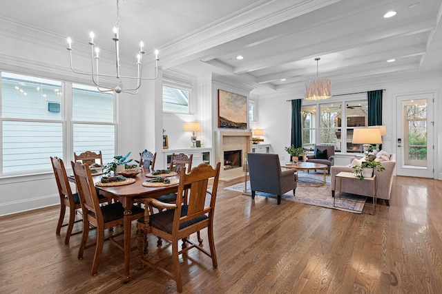 dining space with beamed ceiling, crown molding, a chandelier, and hardwood / wood-style floors