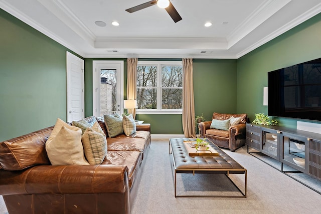 living room with crown molding, a tray ceiling, and carpet floors