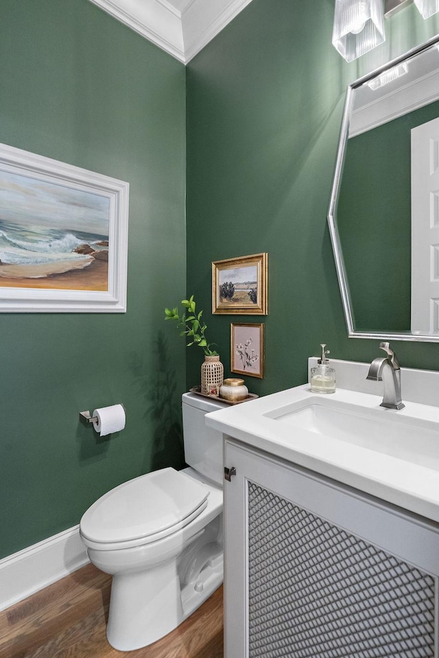 bathroom featuring vanity, wood-type flooring, crown molding, and toilet