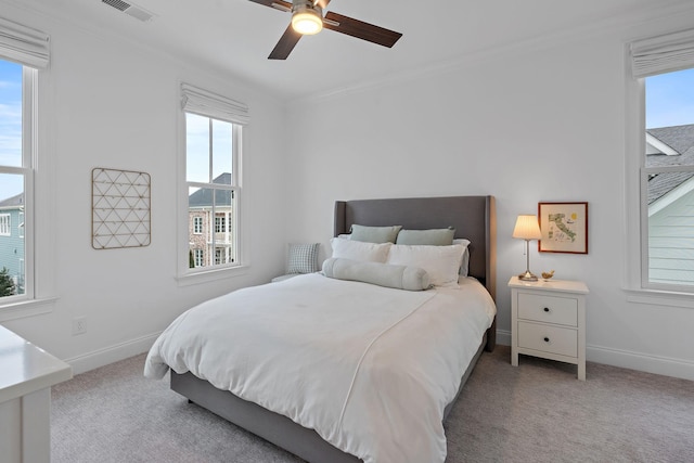 bedroom featuring ornamental molding, light colored carpet, and ceiling fan