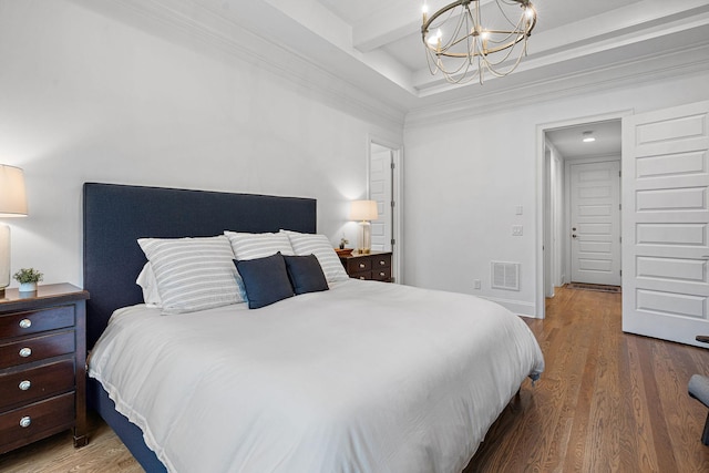 bedroom featuring hardwood / wood-style flooring, ornamental molding, a chandelier, and beam ceiling