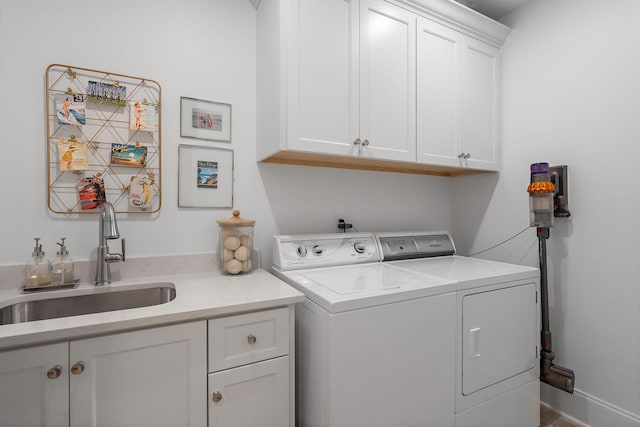 laundry area with cabinets, separate washer and dryer, and sink