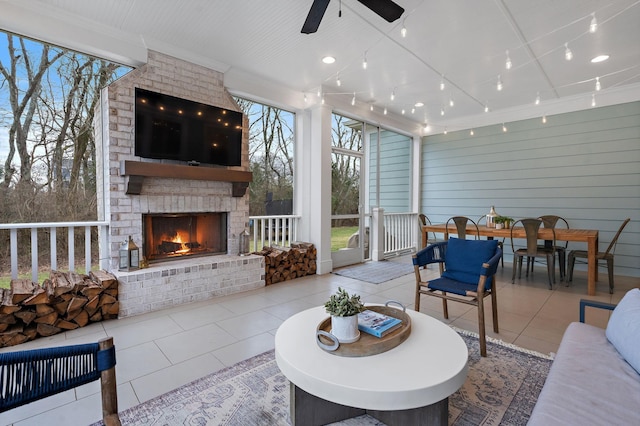 living room with light tile patterned floors, track lighting, a large fireplace, and ceiling fan