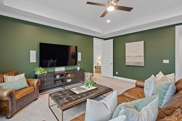 living room featuring crown molding, light colored carpet, a raised ceiling, and ceiling fan