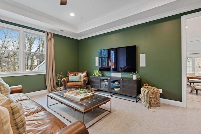 living room featuring a tray ceiling, ornamental molding, and light colored carpet