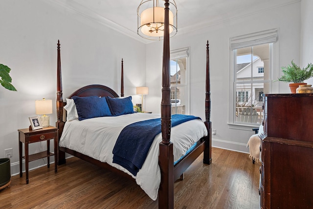 bedroom with dark hardwood / wood-style flooring and crown molding