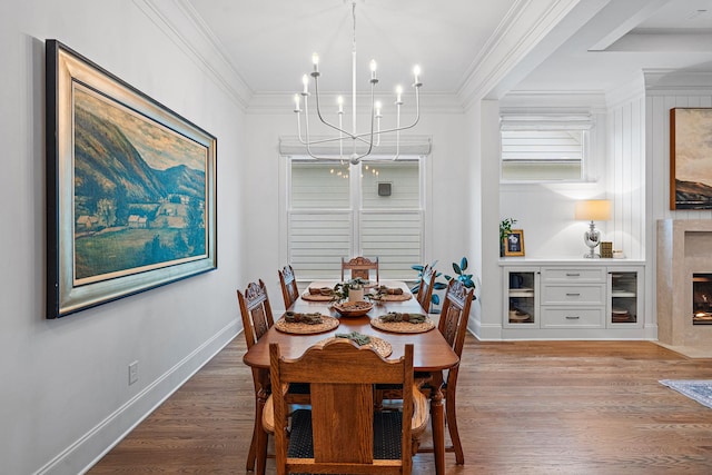 dining area featuring crown molding, wood-type flooring, and a chandelier