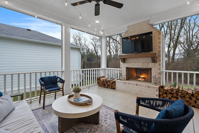 sunroom with an outdoor brick fireplace, ceiling fan, and a healthy amount of sunlight