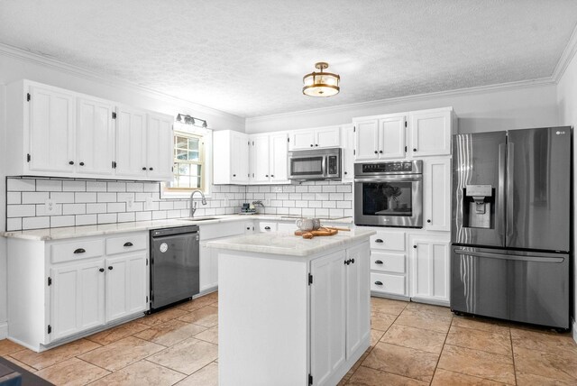 kitchen with ornamental molding, stainless steel appliances, a kitchen island, and white cabinets