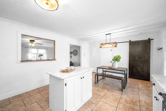 kitchen with pendant lighting, a center island, a textured ceiling, white cabinets, and a barn door