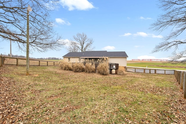 rear view of property featuring a rural view and a lawn