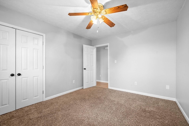 unfurnished bedroom featuring ceiling fan, a closet, carpet, and a textured ceiling