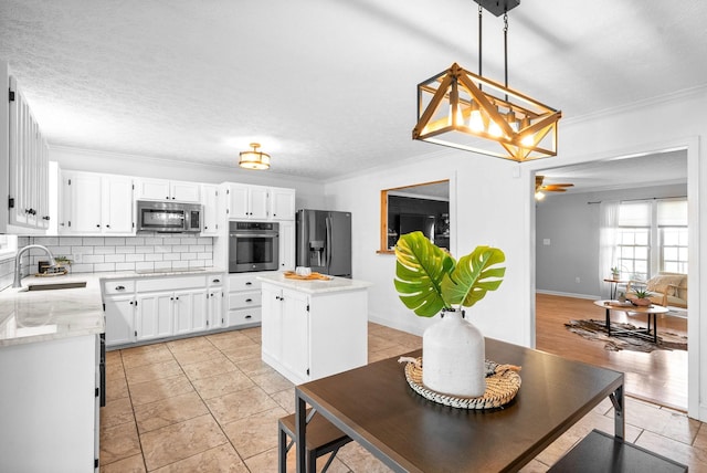 kitchen featuring a kitchen island, white cabinetry, appliances with stainless steel finishes, and sink