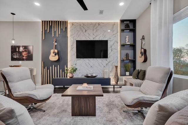 living room featuring built in features and light hardwood / wood-style flooring