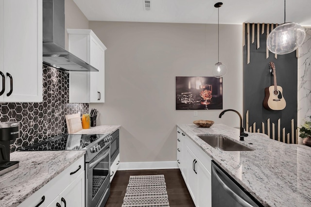 kitchen featuring sink, appliances with stainless steel finishes, hanging light fixtures, white cabinets, and wall chimney exhaust hood