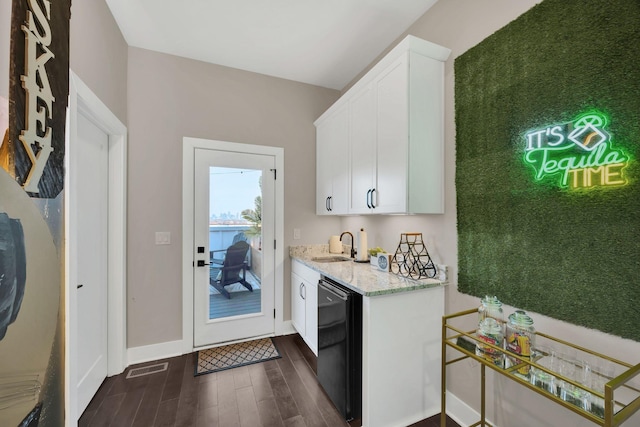 kitchen featuring white cabinetry, sink, black dishwasher, dark hardwood / wood-style flooring, and light stone counters