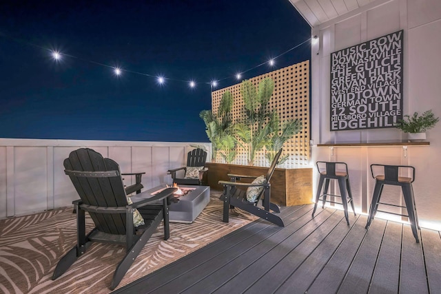 deck at night with a fire pit