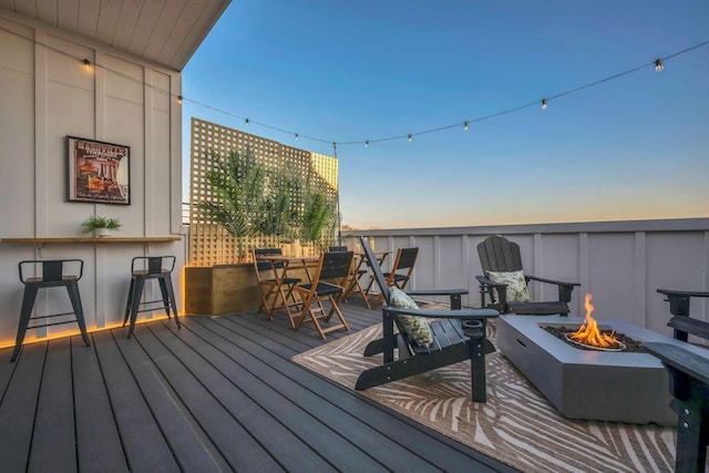 deck at dusk with a bar and a fire pit