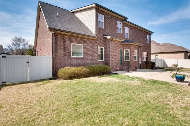 back of property with a yard and a patio area