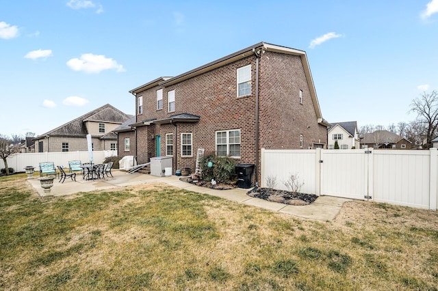 back of property with a yard and a patio area