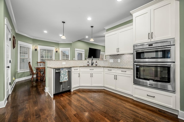 kitchen with white cabinetry, stainless steel appliances, kitchen peninsula, and hanging light fixtures