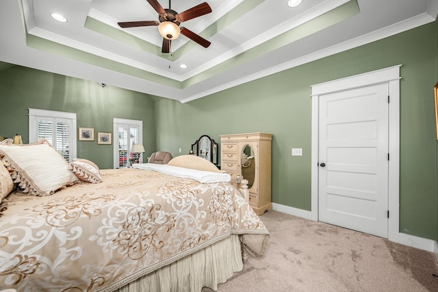 bedroom featuring crown molding, light colored carpet, and a raised ceiling