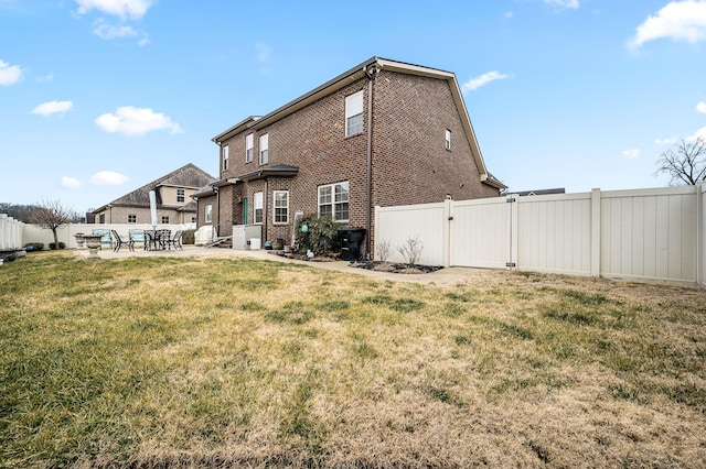 back of property with a yard and a patio area