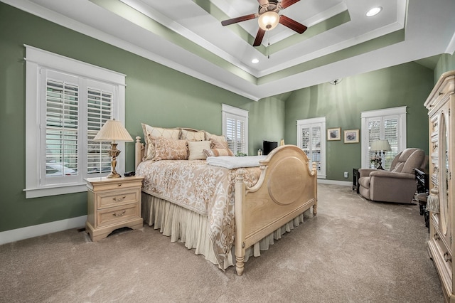 carpeted bedroom featuring ornamental molding, ceiling fan, and a tray ceiling