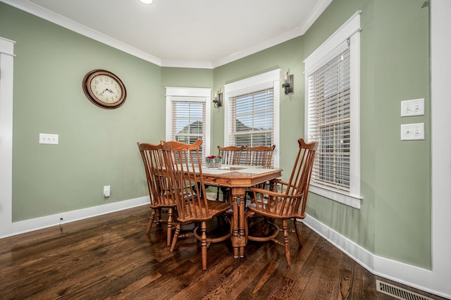 dining area with ornamental molding and dark hardwood / wood-style flooring