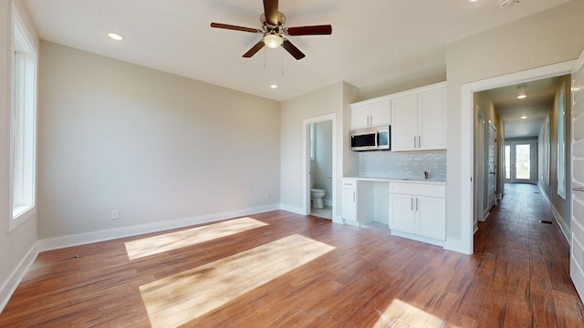 kitchen featuring tasteful backsplash, white cabinetry, dark hardwood / wood-style floors, and ceiling fan