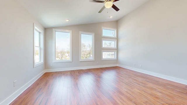 empty room with ceiling fan, lofted ceiling, and light wood-type flooring