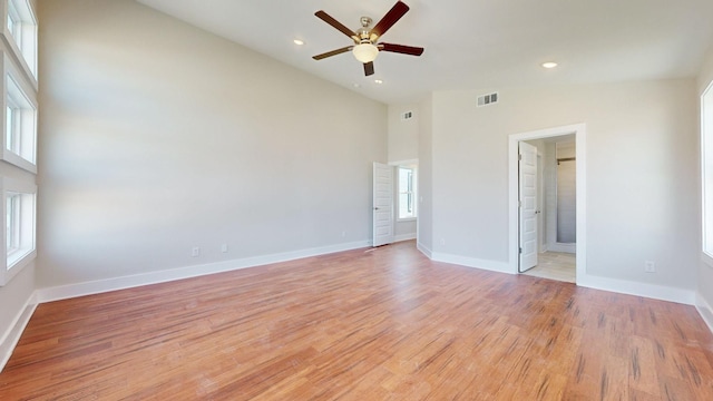 empty room featuring light hardwood / wood-style flooring, high vaulted ceiling, and ceiling fan