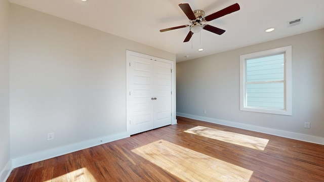 unfurnished bedroom featuring wood-type flooring, ceiling fan, and a closet