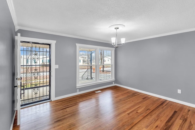 unfurnished dining area with hardwood / wood-style flooring, crown molding, a chandelier, and a textured ceiling