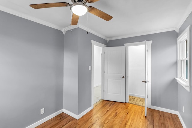 unfurnished bedroom with ornamental molding, ceiling fan, and light wood-type flooring