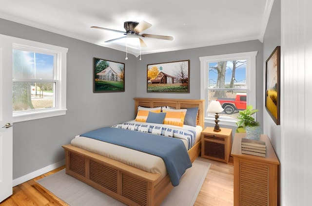 bedroom with multiple windows, crown molding, and light hardwood / wood-style flooring