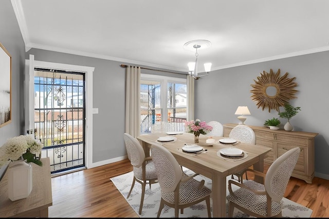 dining room with crown molding, a healthy amount of sunlight, and light hardwood / wood-style flooring