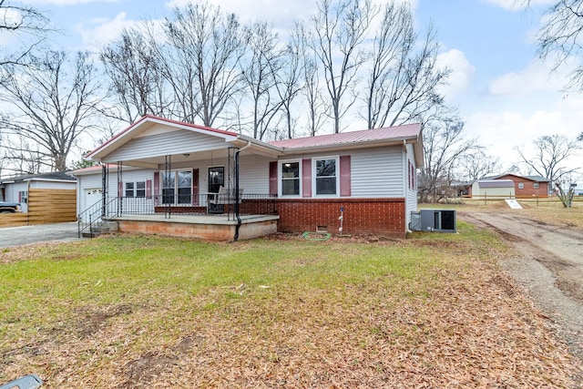 view of front of house with a porch, a garage, central AC unit, and a front lawn