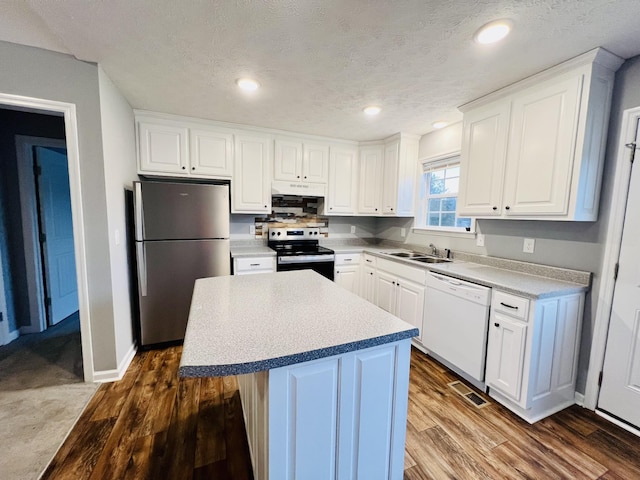 kitchen featuring a center island, a textured ceiling, appliances with stainless steel finishes, hardwood / wood-style flooring, and white cabinets