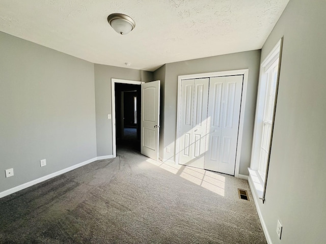 unfurnished bedroom featuring a closet, a textured ceiling, and carpet