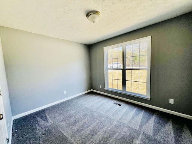 carpeted spare room with a textured ceiling