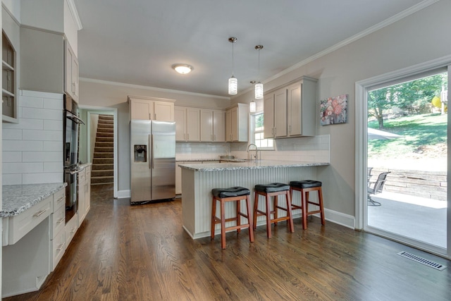 kitchen featuring ornamental molding, dark hardwood / wood-style floors, stainless steel fridge, and decorative light fixtures