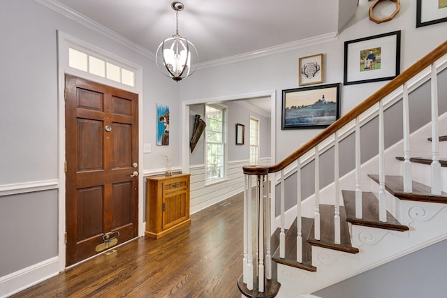 foyer entrance featuring crown molding, dark hardwood / wood-style flooring, and a notable chandelier