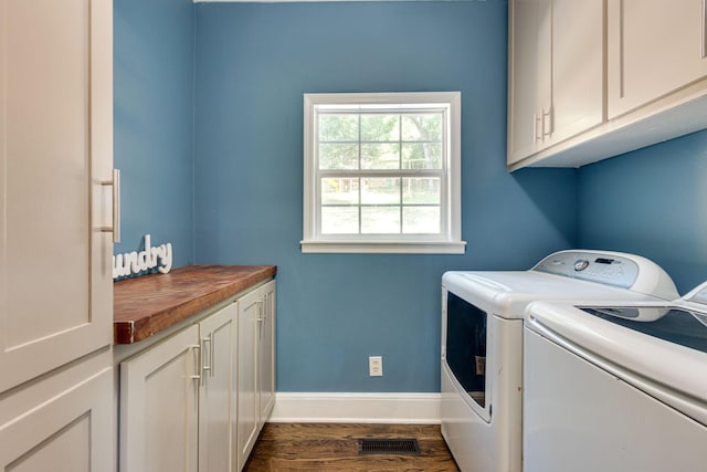 laundry room featuring independent washer and dryer, cabinets, and dark wood-type flooring