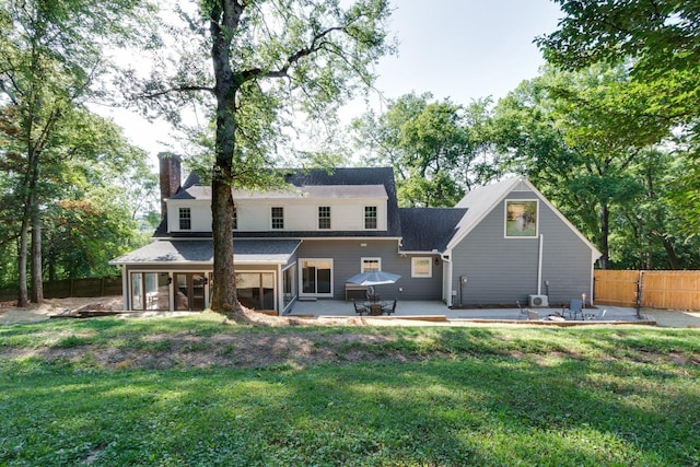 back of property with a patio area and a lawn