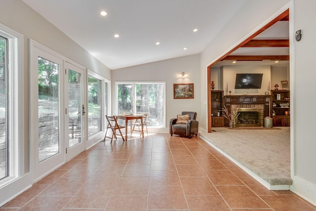 interior space featuring light carpet, vaulted ceiling, and a brick fireplace