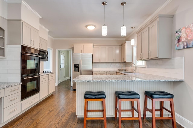 kitchen featuring sink, ornamental molding, dark hardwood / wood-style flooring, stainless steel appliances, and light stone countertops